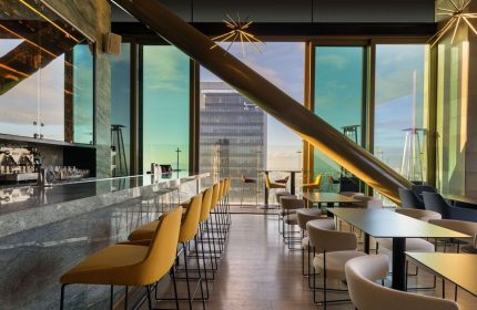 Sofitel Mexico City Reforma's gay-friendly bar. Modern interior with city views, bar stools, tables, and unique architectural details.