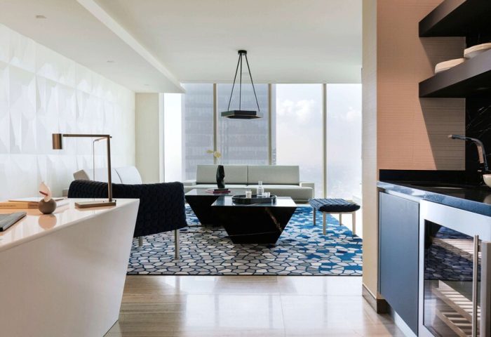 Sofitel Mexico City Reforma suite. Gay-friendly hotel living room with modern decor, blue rug, and city view. Luxury travel in Mexico City.