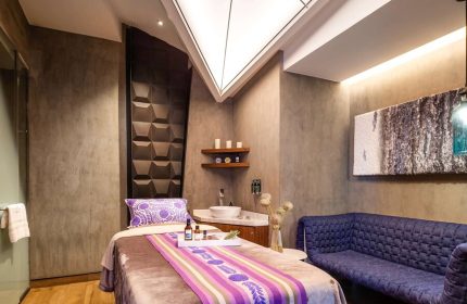 Spa room at the gay-friendly Sofitel Mexico City Reforma hotel. Massage table, purple accents, and modern design for relaxing gay travel.