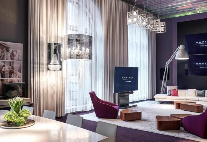 Sofitel Munich Bayerpost Hotel interior. Gay-friendly hotel room with modern design, chandeliers, and TV. Luxury Munich hotel for gay travelers.