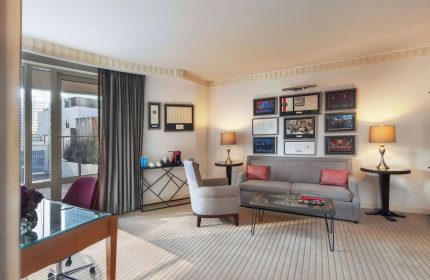 Sofitel New York's gay-friendly hotel room. The suite features a desk, sofa, and balcony, offering a luxurious stay in NYC for gay travelers.