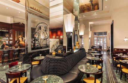 Sofitel New York's luxurious interior. A gay-friendly hotel with a bar and dining area. Marble floors and elegant decor. Perfect for gay travel.