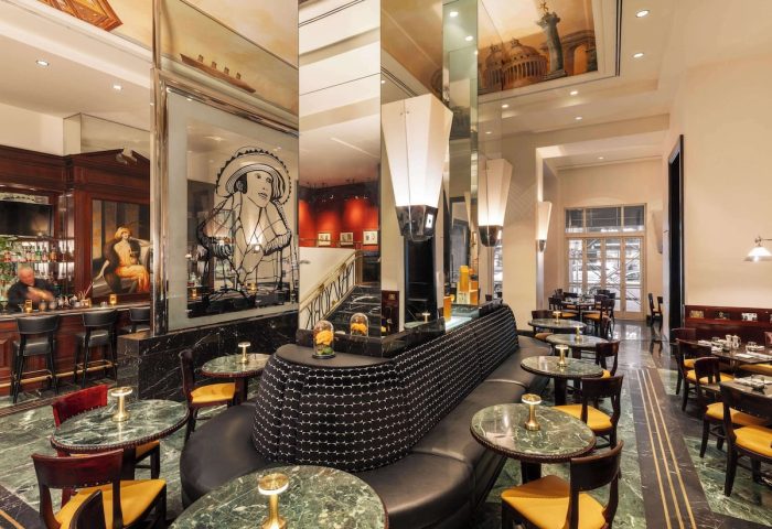 Sofitel New York's luxurious interior. A gay-friendly hotel with a bar and dining area. Marble floors and elegant decor. Perfect for gay travel.