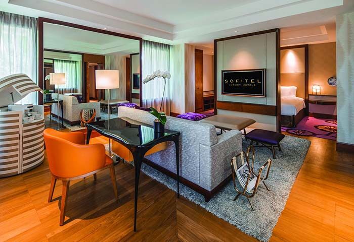 Sofitel Singapore Sentosa Resort & Spa suite. Gay-friendly hotel with living room, bedroom, TV, desk, and seating. SG Clean Certified.
