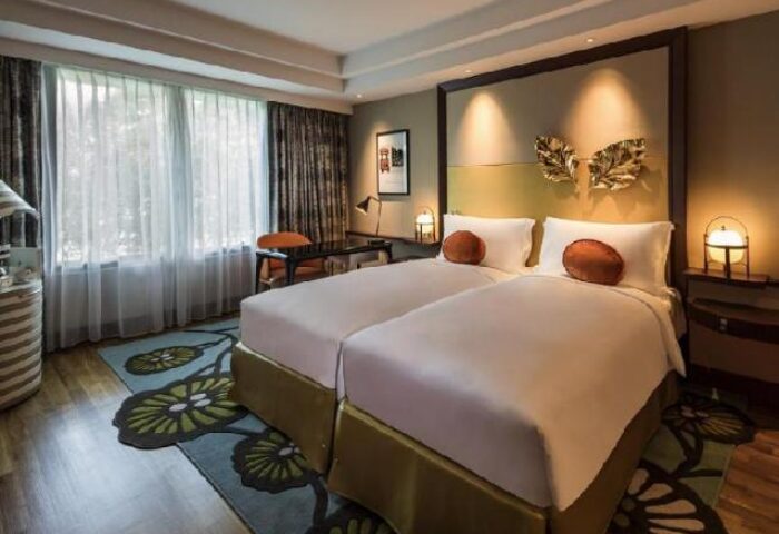Sofitel Singapore Sentosa Resort & Spa room. Gay-friendly hotel with twin beds, desk, and floral rug. SG Clean Certified. Gay travel.