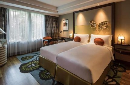 Sofitel Singapore Sentosa Resort & Spa room. Gay-friendly hotel with twin beds, desk, and floral rug. SG Clean Certified. Gay travel.