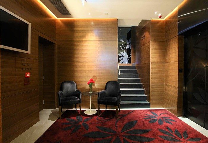 Sohotel's stylish lobby interior. This gay-friendly hotel features modern design, wood paneling, plush seating, and a vibrant red rug.