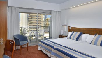 Sol Costablanca Adults-only Hotel room. Gay-friendly hotel room with balcony view in Benidorm, Costa Blanca, Spain. Twin beds with blue accents.