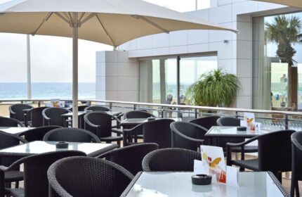 Sol Costablanca Adults-only Hotel: Outdoor terrace with tables, chairs, and ocean view. Gay-friendly hotel in Spain.