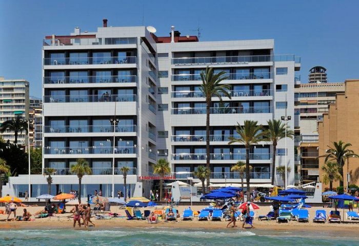 Sol Costablanca Adults-only hotel. Gay-friendly hotel on the beach. People enjoy the beach in front of the hotel. Palm trees.