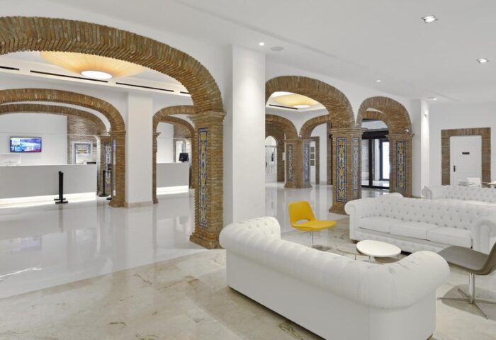 Sol Torremolinos Don Pablo hotel lobby. Arched brick columns, white sofas, and marble floors create a stylish, gay-friendly space.
