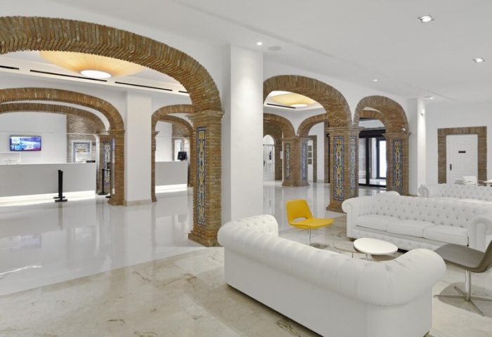 Sol Torremolinos Don Pablo hotel lobby. Arched brick columns, white sofas, and marble floors create a stylish, gay-friendly space.