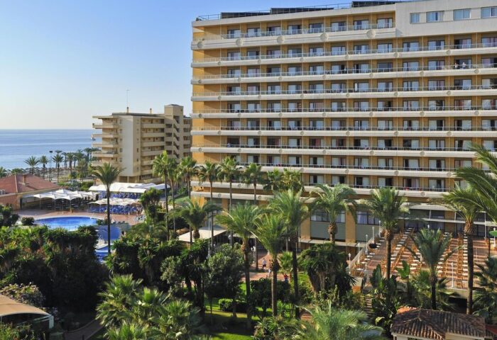 Sol Torremolinos Don Pablo, a gay-friendly hotel. Features include a pool, palm trees, and balconies with ocean views. Perfect for gay travel.