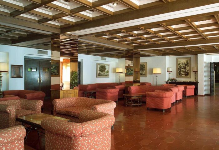 Lobby at Sol Torremolinos Don Pedro, a gay-friendly hotel. Seating area with sofas, chairs, and tables. Coffered ceiling and tile floor.