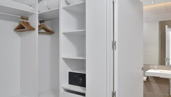 Sol Torremolinos Don Pedro gay-friendly hotel room closet. Open wardrobe with hangers, shelves, safe, and bathroom view.