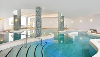 Sol Torremolinos Don Pedro gay-friendly hotel's indoor pool. Modern design with tiled pillars and curved edges. Ideal for gay travel.