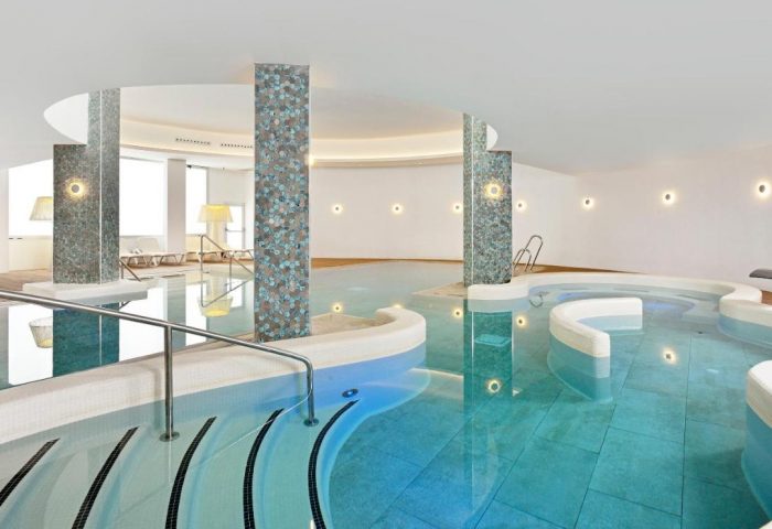 Sol Torremolinos Don Pedro gay-friendly hotel's indoor pool. Modern design with tiled pillars and curved edges. Ideal for gay travel.