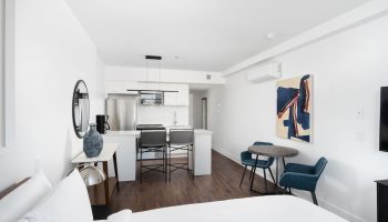 Sonder Gare Saint Denis gay-friendly hotel room. Modern interior with kitchen, table, chairs, and bed. Great for gay travel in Paris.