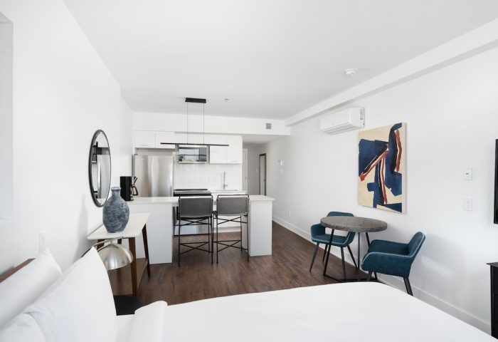 Sonder Gare Saint Denis gay-friendly hotel room. Modern interior with kitchen, table, chairs, and bed. Great for gay travel in Paris.