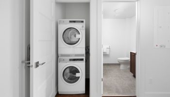 Sonder Gare Saint Denis: Washer and dryer in a closet. Bathroom visible through doorway. Gay-friendly hotel with modern amenities.