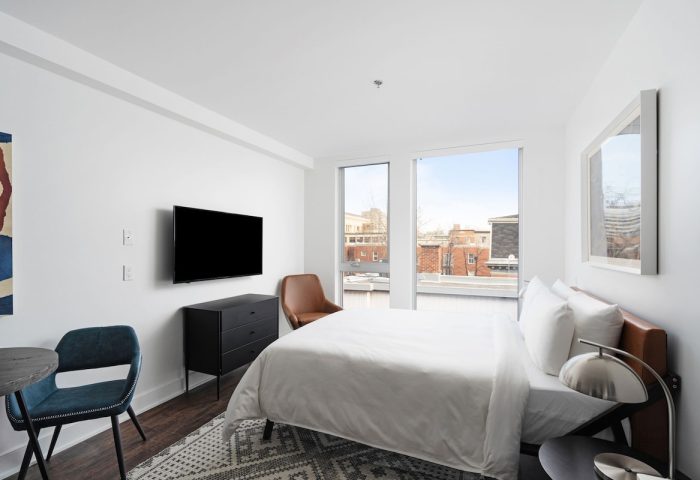 Sonder Gare Saint Denis gay-friendly hotel room. Clean design with a bed, TV, dresser, table and chairs. Modern, bright, and comfortable.