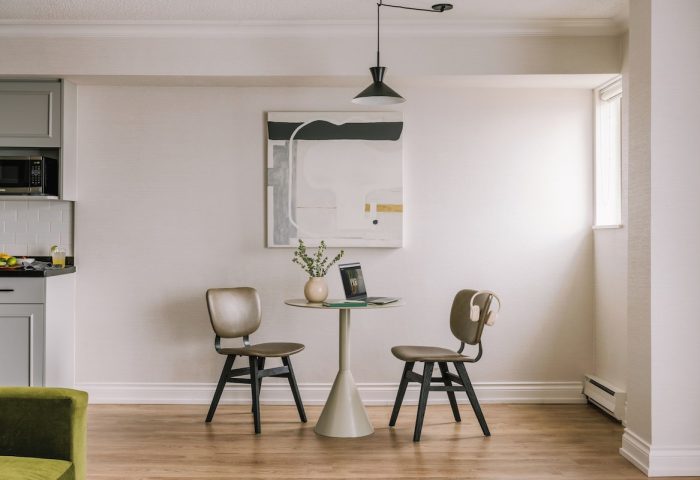 Sonder The Sunset gay-friendly hotel room. Dining table with laptop, chairs, and modern art. A comfortable space for gay travelers.