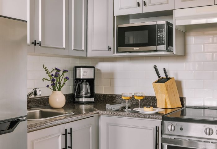 Sonder The Sunset's kitchen. Gay-friendly hotel with stainless fridge, microwave, coffee maker, stove, two drinks, and a knife block.