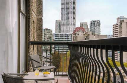 Balcony view from Sonder The Sunset, a gay-friendly hotel. Drinks, chairs, and city skyline. Ideal for gay travel and relaxation.