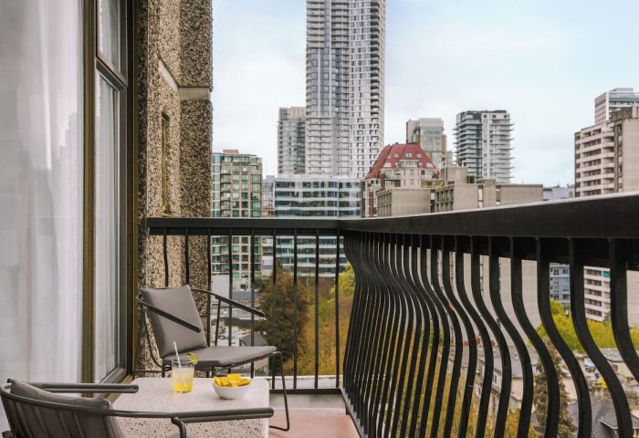 Balcony view from Sonder The Sunset, a gay-friendly hotel. Drinks, chairs, and city skyline. Ideal for gay travel and relaxation.