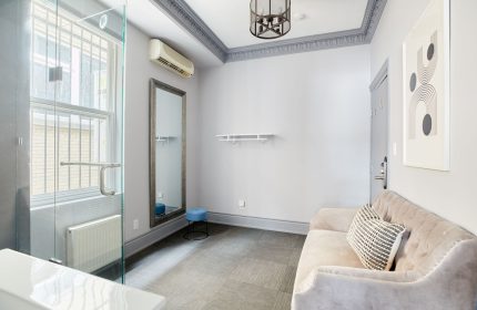 Sonder The Wellesley gay-friendly hotel room. Interior view with sofa, mirror, and shower. Modern design for gay travelers.