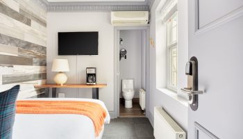 Sonder The Wellesley, gay-friendly hotel room. View of bed, TV, coffee maker, and bathroom. Modern design for gay men travelers.