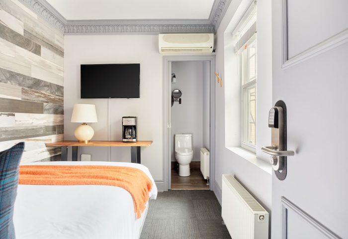 Sonder The Wellesley, gay-friendly hotel room. View of bed, TV, coffee maker, and bathroom. Modern design for gay men travelers.