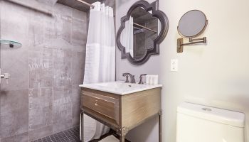 Sonder The Wellesley's bathroom. Gay-friendly hotel with shower, sink, and toilet. Mirror and decorative tile add style to this hotel bathroom.