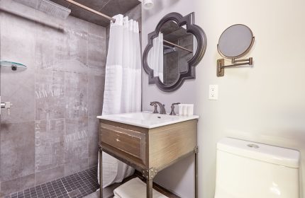 Sonder The Wellesley's bathroom. Gay-friendly hotel with shower, sink, and toilet. Mirror and decorative tile add style to this hotel bathroom.