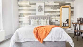 Sonder The Wellesley hotel room. Gay-friendly travel lodging with bed, orange throw, and decor. Modern design at this top gay travel destination.