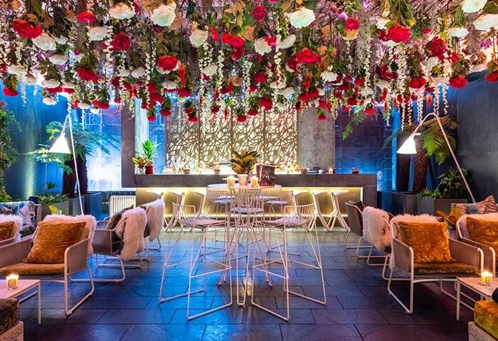 South Place Hotel's stylish bar area. Floral ceiling decor, cozy seating. A gay-friendly, pet-friendly hotel with a unique ambiance.