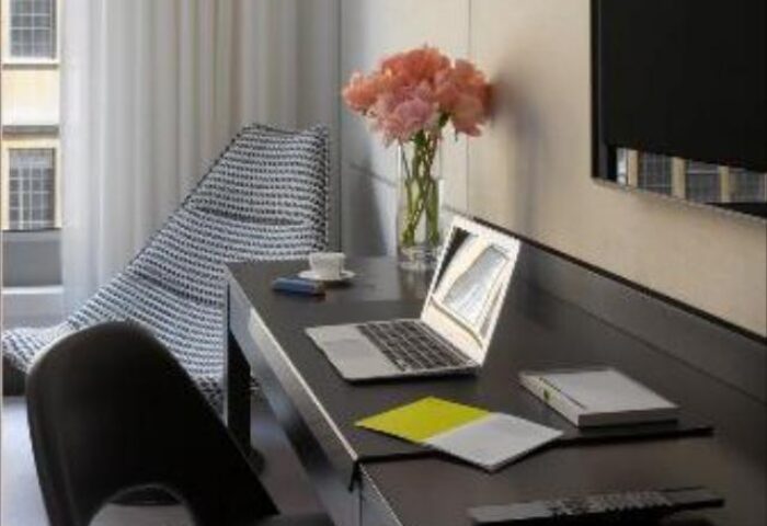 South Place Hotel's pet-friendly room: Desk with laptop, flowers, & chair. A gay-friendly hotel offering comfort & style for all travelers.