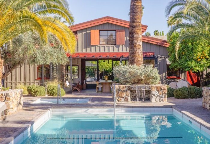 Sparrows Lodge, a gay-friendly hotel: Pool view of the hotel exterior, with palm trees, stone accents, and a tranquil, inviting atmosphere.