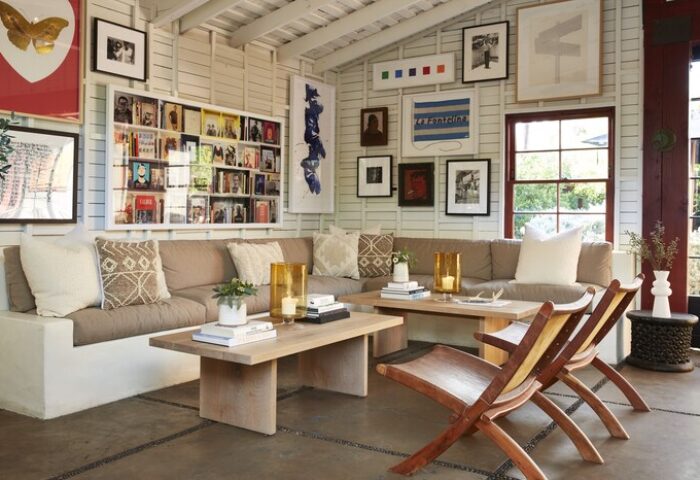 Sparrows Lodge's stylish living area. A gay-friendly hotel with a cozy couch, wooden chairs, and unique art. Gay travel advice for Palm Springs.