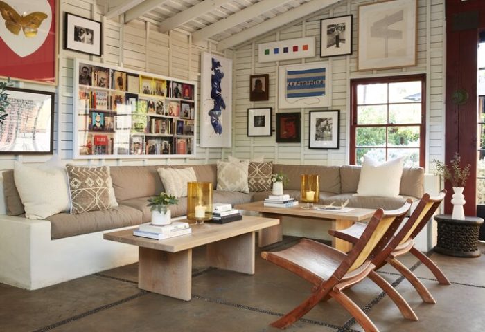 Sparrows Lodge's stylish living area. A gay-friendly hotel with a cozy couch, wooden chairs, and unique art. Gay travel advice for Palm Springs.