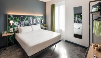 Spice Hotel Milano gay-friendly room. Stylish interior with double bed, chalkboard headboard, and modern decor. Perfect for gay travelers.