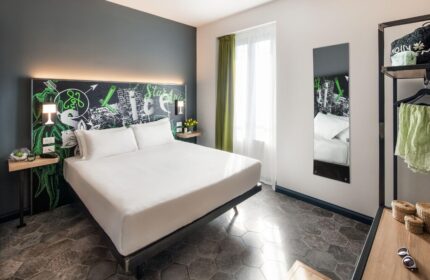 Spice Hotel Milano gay-friendly room. Stylish interior with double bed, chalkboard headboard, and modern decor. Perfect for gay travelers.