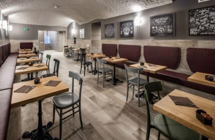 Spice Hotel Milano gay-friendly hotel restaurant. Tables and chairs line the room, with booth seating along one wall. Chalkboard art decorates.