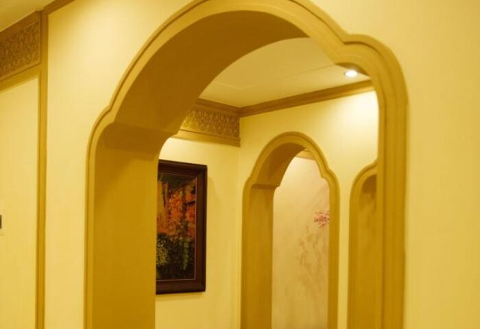 Arched doorways at Spring Flower Hotel, a gay-friendly hotel. A painting hangs on the wall. Interior design details add charm to this hotel.