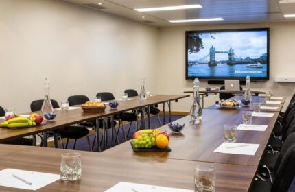 St Giles London Hotel conference room. Meeting space with fruit, water, and view of Tower Bridge. Gay-friendly hotel in London.