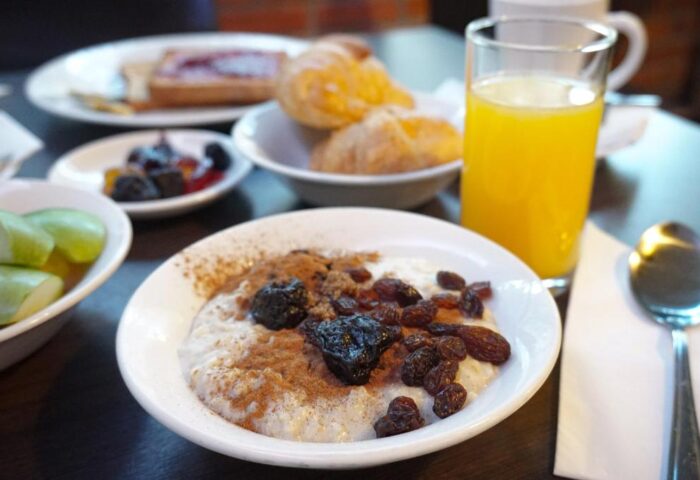 Breakfast at St Giles London Hotel. Oatmeal with raisins, plums and cinnamon. Croissants, toast, fruit, and orange juice. Gay-friendly hotel.
