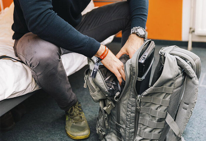Gay traveler packing at St. Christopher's Hostel Berlin. Man with backpack in gay-friendly hotel room. Travel advice for gay men in Berlin.
