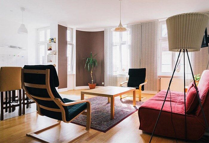 St. Christopher's Hostel Berlin living area. Gay-friendly hotel room with chairs, sofa, table, and lamp. Comfortable, modern interior.