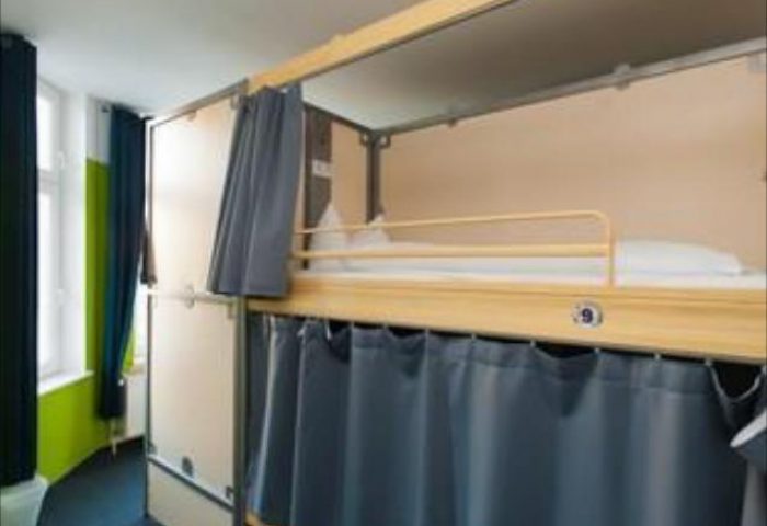 Dorm room at St. Christopher's Hostel in Berlin. Bunk beds with privacy curtains. Gay-friendly hotel for travelers. Budget accommodation.