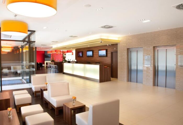 Star Inn Hotel Wien Schönbrunn lobby. Gay-friendly hotel with modern design, reception, seating area, and elevators. Vienna, Austria.